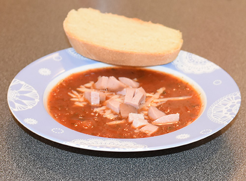 Tomatsuppe med pølse, revet ost og brød