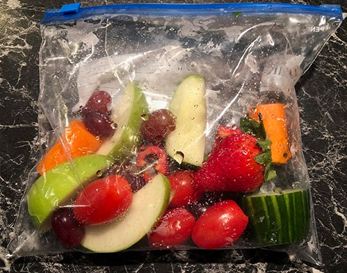 Oppskåret og skylt gulrot, eple, pære, stangselleri, agurk, cherrytomater, jordbær, sukkererter og druer