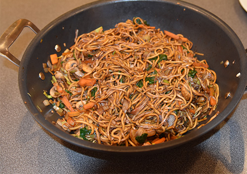 Wok med Eggenudler Olje (nøytral) Løk (tynne skiver) Gulrøtter (i staver) Sjampinjonger (i ¼ -deler) Spinat Bønnespirer Purreløk (i staver) Soyasaus (mørk) Sukker (brunt) Sesamolje Chiliolje (valgfritt)