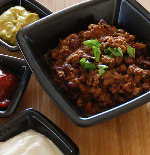 Chili con carne Ingredienser 1 Løk (liten) 1 Gulrot (liten) 1-2 fedd Hvitløk ¼ - ½ Chili (rød) 400 g Kjøttdeig 1 bx Tomater (hermetiske) 2 ts Persille (tørket) 1½ - 2 ts Spiskummin 1½ ts Koriander 2 ts Paprikapulver ½ ts Gurkemeie 1 ts Salt ¼ ts Pepper 300-400 g Bønner (Kidney, ferdig kokte)