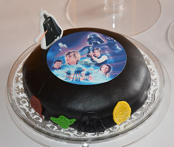 Kaka består som sagt av tre kaker, satt opp på et kakestativ for bryllupskaker. Alle tre kakene har Star Wars tema. Den første kaka er en svart og har "undertemaet": Darth Vader. Siden han er mørk består denne kaken av saftig sjokoladekake fylt med sjokolademousse. Syntes sjokoladekake passet godt til undertemaet. Som pynt på den svarte marsipanen er det et noen figurer fra Star Wars, et Darth Vader kakelys og et Star Wars kakebilde som skulle smelte ned i kaka, men som faktisk ikke gjorde det - så vi tok det vekk, når kaka ble sprettet.