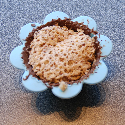 Suksessmakroner (etter oppskrift fra Baker Brun) Ingredienser: Topping: 200 g Kokesjokolade 15 Muffinsformer Suksesskrem: 1 dl Kremfløte 125 g Sukker 4 Eggeplommer 1 Vaniljestang (2 ts vaniljesukker) 150 g Smør (ekte) Mandelbunn: 500 g Mandler 500 g Sukker 7 Eggehviter