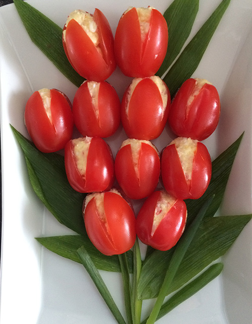 Fylte tomater Ingredienser 6 Små harde tomater 1 Hardkokt egg 1 porsjon Crabsticks salat 1 Salatblad Cherrytomater, persille eller dill til pynt