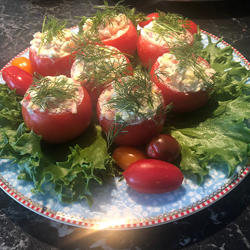 Fylte tomater Ingredienser 6 Små harde tomater 1 Hardkokt egg 1 porsjon Crabsticks salat 1 Salatblad Cherrytomater, persille eller dill til pynt