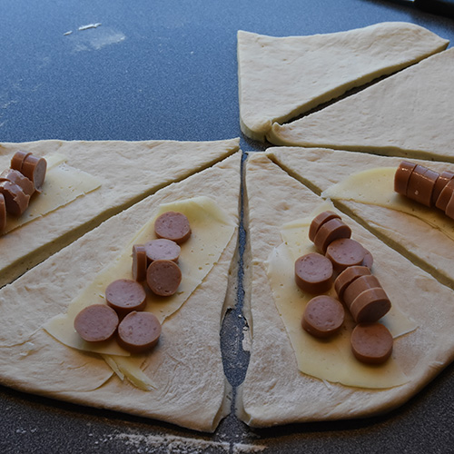 Pølsehorn  Ingredienser  1 porsjon	Horn (trykk her for oppskrift) 6-8	Pølser 32 skiver	Hvitost