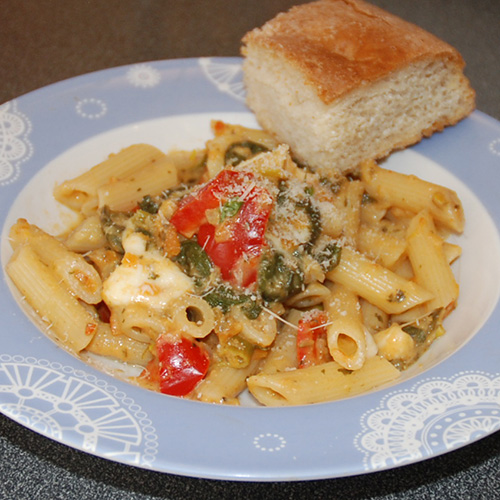 Penne med Kremet saus med tomat og mozzarella i hvit bolle Ingredienser: 1 ss 	Olje 1 ss 	Smør  1 	Løk  1 	Gulrøtter  ½ stilk	Selleri  1 fedd 	Hvitløk  ¼ 	Chili (rød, uten frø)  ½  	Purre  4 	Tomater (store)  1 	Paprika (rød) 1 ss 	Persille (hakket)  1 ts 	Paprikapulver  ½ ts	Pepper 1 dl 	Grønsakskraft (buljong)  100 g	Spinat ½ -1 dl 	Fløte  400-500 g 	Pasta (penne)   	Salt, pepper    	Parmesan (raspet)  	Basilikum