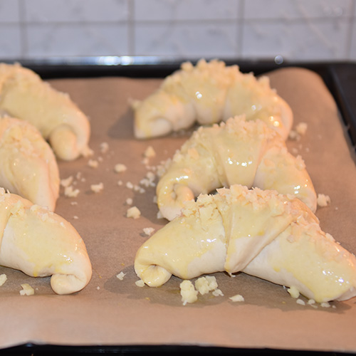 Ostehorn etter oppskrift fra baker brun Ingredienser: 13 dl Hvetemel 1 pk Gjær 2 ss Sukker 1 ts Salt 65 g Margarin 2½ dl Melk 3 dl Vann Egg (sammenvispet) Hvit ost (revet)