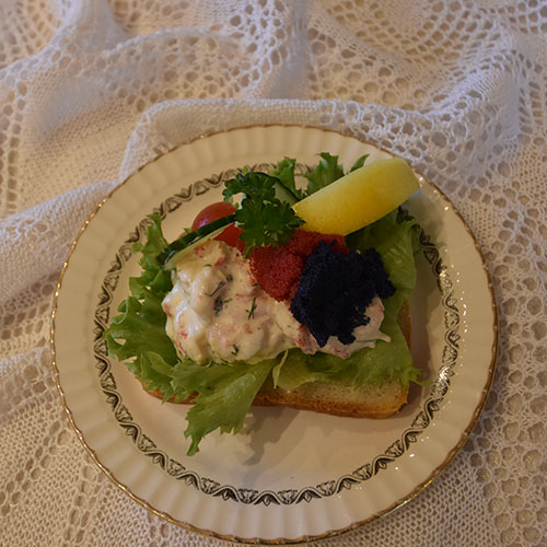 Ingrids Skagensrøre Ingredienser: 2 dl Rømme 2 ss Majones 1 ts Sennep ½ ts Søt chilisaus 2 ss Rødløk (finhakket) 2 ss Dill (finhakket) 2 ts Sitronskall (finraspet) 200 g Reker (renskede) 200 g Krepsehaler (renskede) Salt, pepper 4 Salatblader 4 ts Rogn ½ Sitron