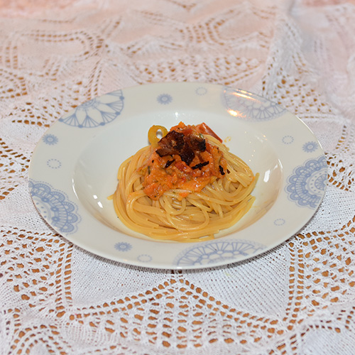 Spagetti med tomatsaus, bacon, paprika, purre og ost Ingredienser: 1 ss Olje 1 ss Smør ½ Løk (liten) 1 Gulrot (liten) 1 stilk Stangselleri ¼ Purre 2 fedd Hvitløk ¼ Chili (rød, uten frø) 6 Tomat (flodde) 3 dl Grønsakskraft (buljong) ¼ Purreløk ½ Paprika 1 ss Persille (hakket) 1 ts Paprikapulver ¼ ts Sukker 250 g Bacon (sprøstekt) 100 g Hvitost (revet) 300-400 g Spagetti Salt, pepper Basilikum (hakket)