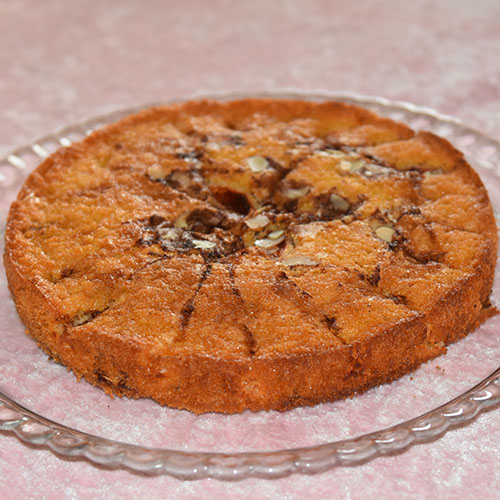 Eplekake etter oppskrift fra Baker Brun Ingredienser: 200 g Sukker 200 g Smør (smeltet) 4 Egg 110 g Hvetemel 1½ ts Bakepulver 3 Epler (i biter) 1 ½ ts Kanel (malt) 2 ss Sukker 60 g Hakkete mandler