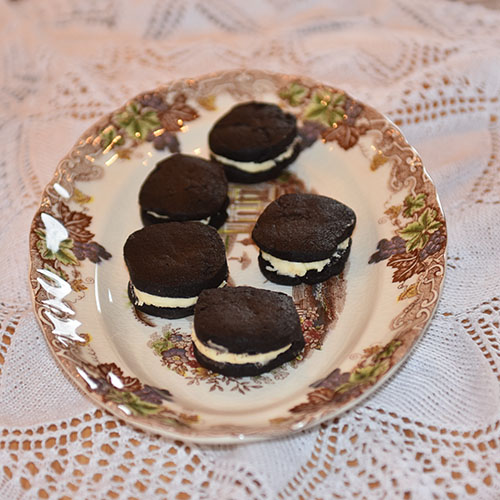 Oreokjeks Ingredienser 225 g Smør (smeltet og avkjølt) 150 g Sukker 1 ts Vaniljeekstrakt (-sukker) 200 g Kokesjokolade (smeltet og avkjølt) 1 Egg 200 g Hvetemel 100 g Kakao 1 ts Salt ½ ts Bakepulver Fyll: 100 g Smør (mykt) 4 dl Melis 1 ss Melk 1 ts Vaniljeekstrakt (-sukker) 1 knivsodd Salt