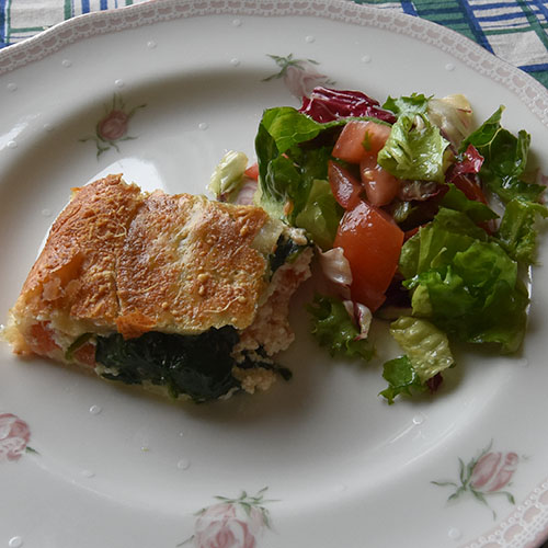 Spinat- og Ricottaterte med tomater Ingredienser: 300 g Butterdeigplater (dypfryste) 2 Tomater (tynne skiver) 1 pk Spinat 2 ss Smør 250 g Ricotta(ost) 100 g Hvit ost (revet) 3 ss Parmesan 10 blad Basilikum 1 Egg (sammenvispet) Salt, pepper 1 Eggeplomme 2 ss Parmesan (til strø)