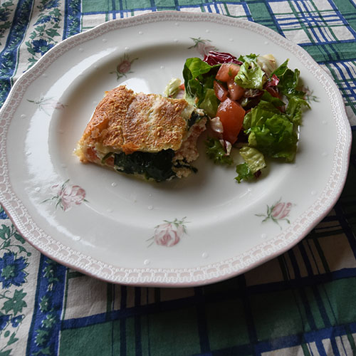 Spinat- og Ricottaterte med tomater Ingredienser: 300 g Butterdeigplater (dypfryste) 2 Tomater (tynne skiver) 1 pk Spinat 2 ss Smør 250 g Ricotta(ost) 100 g Hvit ost (revet) 3 ss Parmesan 10 blad Basilikum 1 Egg (sammenvispet) Salt, pepper 1 Eggeplomme 2 ss Parmesan (til strø)