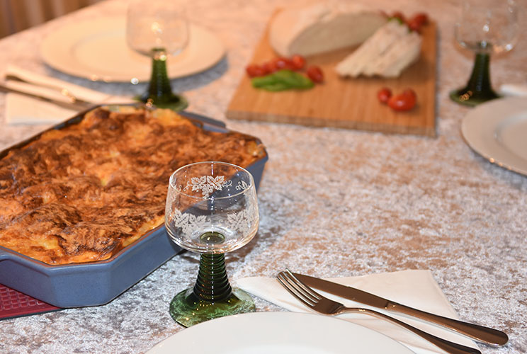 Lasagne al forno Ingredienser: Kjøttsaus: 2 ss Oliven olje 1 Løk 1 Gulrot 1 stilk Stangselleri 1 fedd Hvitløk ½ Chili (rød – uten frø) eller (kajennepepper) 350 g Kjøttdeig 50 g Bacon (kan sløyfes) 2 bx Hermetiske tomater 1 dl Vann (eller hvitvin) 1-2 Buljongterninger ½ - 1 ts Sukker Bladpersille (hakket) Salt og Pepper Ostesaus: 4 ss Hvetemel 8 dl Melk 1 ts Salt ½ ts Pepper 100-200 g Ost (revet)