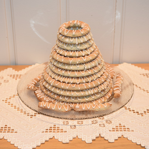 Kransekake / tårnkake etter oppskrift fra Baker Brun (2018), «Våre beste oppskrifter. 125 år med tradisjonsbakst, side 80-81» Ingredienser: 500 g Mandler (malte) 500 g melis 3-4 Eggehviter Melis glasur 180 g Melis 1 Eggehvite 5 dråper Sitronsaft