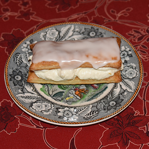 Napoleonskake etter oppskrift fra Baker Brun (2018), «Våre beste oppskrifter. 125 år med tradisjonsbakst, side 74-75» Ingredienser: 4 Butterdeiegsplater 1 ss Hvetemel Krem: 2 Gelatinplater 2 ts Vaniljesukker 3 dl Melk 75 g Sukker 20 g Maisenna 4 dl kremfløte Melisglasur: 200 g Melis 3 ss Vann