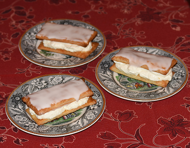 Napoleonskake etter oppskrift fra Baker Brun (2018), «Våre beste oppskrifter. 125 år med tradisjonsbakst, side 74-75» Ingredienser: 4 Butterdeiegsplater 1 ss Hvetemel Krem: 2 Gelatinplater 2 ts Vaniljesukker 3 dl Melk 75 g Sukker 20 g Maisenna 4 dl kremfløte Melisglasur: 200 g Melis 3 ss Vann