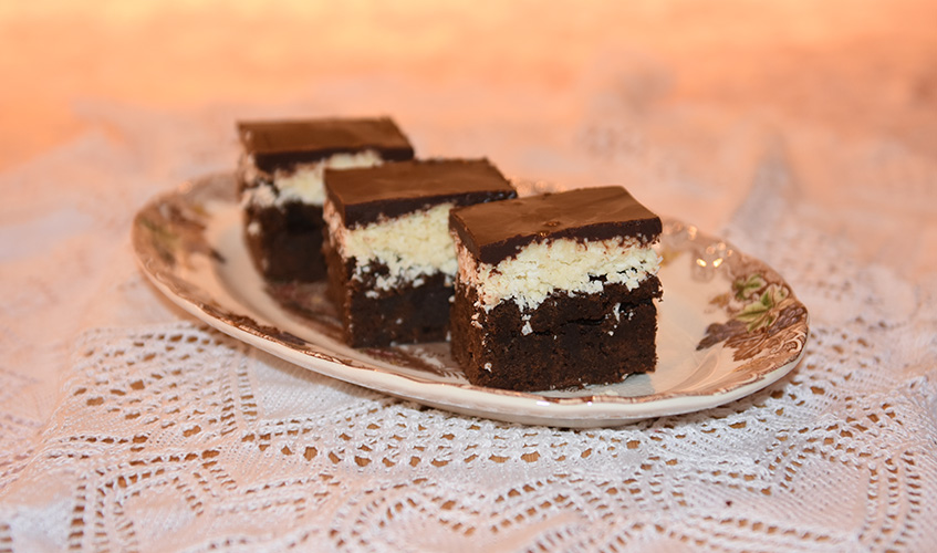 Brownies med kokos- og sjokoladetopping Ingredienser: 160 g Hvetemel 5 ss Kakao 225 g Smør 2 ts Kaffepulver 120 g Brunsukker 200 g Sukker (hvitt) 5 Egg 2 ts Vaniljesukker Kokostopping: 180 g Kondensertmelk (søt) 1 ts Vaniljesukker ¼ ts Salt 400 g Kokos 220 g Melis Sjokoladetopping: 220 g Sjokolade (mørk) 1 ts Sirup (hvit) eller glukose 115 g Smør