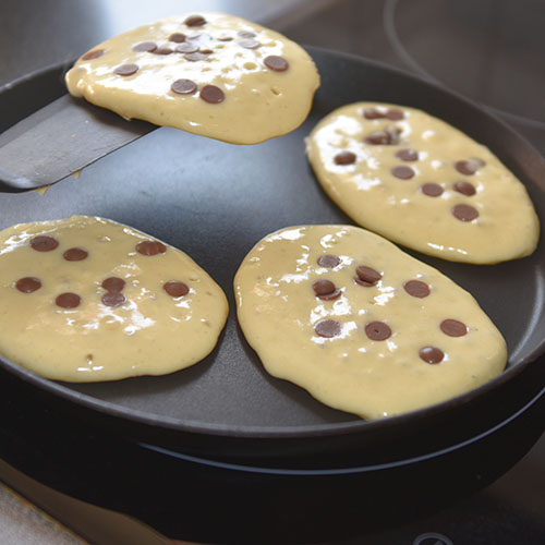 Amerikanske pannekaker med sjokoladebiter Ingredienser: 50 g Smør 2½ dl Melk 2 Egg 3 dl Hvetemel 2 ts Bakepulver ½ ts Salt 1 ss Sukker 100 g sjokoladebiter