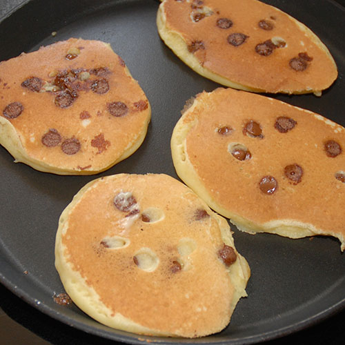 Amerikanske pannekaker med sjokoladebiter Ingredienser: 50 g Smør 2½ dl Melk 2 Egg 3 dl Hvetemel 2 ts Bakepulver ½ ts Salt 1 ss Sukker 100 g sjokoladebiter