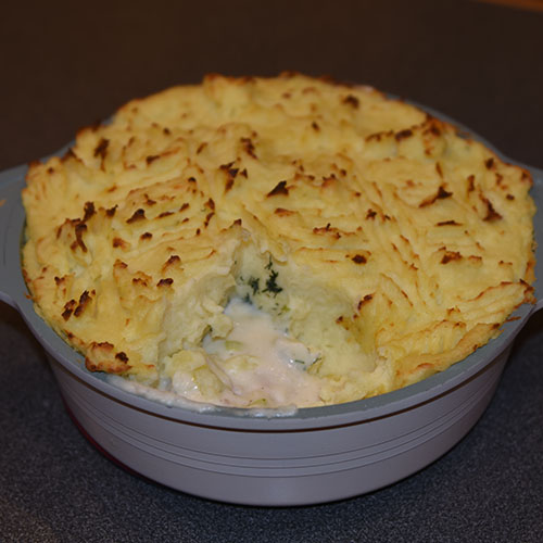 Fiskepai Ingredienser: Potetmosen: 1 ½ kg Poteter (i biter) 2 ss Smør 2 dl Crème fraîche 1 – 2 dl Melk (varm) Salt og pepper Fyllet: 7 ½ dl Melk 3 • Nellikspiker 1 • Lauvbærblad 600 g • Seifillet 6 ss • Smør 1 • Løk (finhakket) 1/2 • Purre (skivet) 4 ss • Hvetemel 1 ss • Persille (finhakket) 1 • Sitron (skall- finraspet) 50 g • Erter (valgfritt) 100 g • Reker (valgfritt) • Salt og pepper