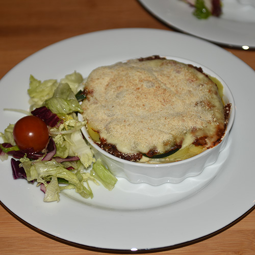 Squash – og tomatpai Ingredienser: 4 Poteter 1 Squash 1 Løk 1 Paprika (grønn) ¼ Purre (ca. 50 g) 1 fedd Hvitløk 1 ts Spisskumen 1 ts Paprikapuver 2 ss Basilikum (hakket) 1 ts Persile (hakket) 1 bx Tomater (hermetiske) 1 Mozzarella Salt og pepper 60 g Strøbrød 2 ss Parmesan 4 Terteformer (små, med løs bunn) Eller noe annet å steke dem i