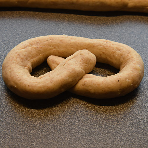 Små ostekringler Ingredienser: ½ pk Gjær 4 dl Vann (fingervarmt) 1 ss Olje (nøytral 2 ts Sukker ½ ts Salt 3 dl Ost (revet, hvit) 1 Egg 4 dl Sammalt hvete (fin) Ca. 6 dl Hvetemel