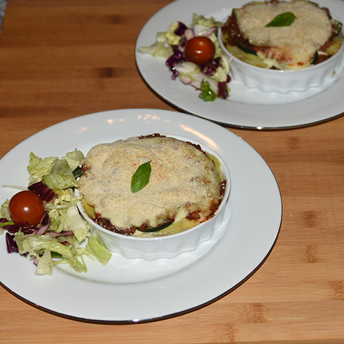 Squash – og tomatpai Ingredienser: 4 Poteter 1 Squash 1 Løk 1 Paprika (grønn) ¼ Purre (ca. 50 g) 1 fedd Hvitløk 1 ts Spisskumen 1 ts Paprikapuver 2 ss Basilikum (hakket) 1 ts Persile (hakket) 1 bx Tomater (hermetiske) 1 Mozzarella Salt og pepper 60 g Strøbrød 2 ss Parmesan 4 Terteformer (små, med løs bunn) Eller noe annet å steke dem i