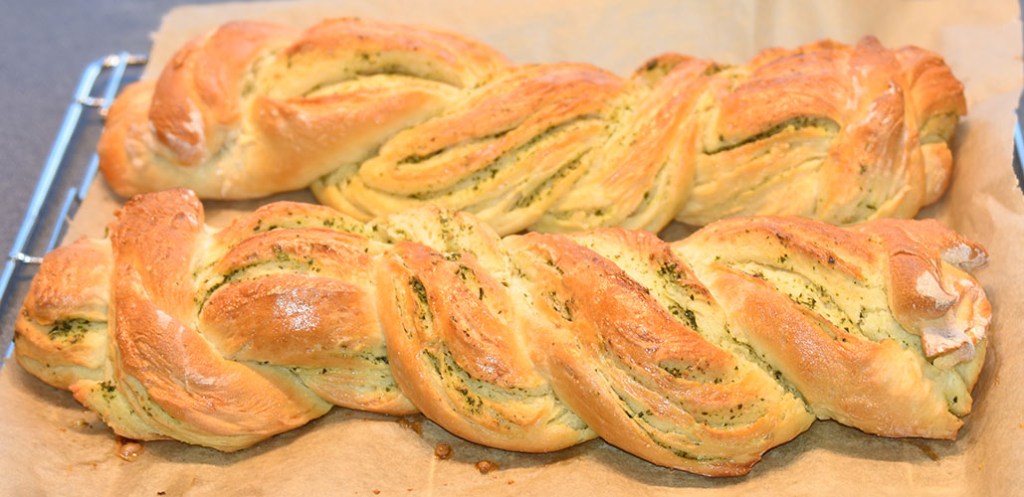 Flettet hvitløk- og basilikumbrød Ingredienser: 1 pk Gjær ½ dl Vann (fingervarmt) ½ ts Sukker 600 g Hvetemel ½ ts Salt 50 g Smør 4 dl Melk (skummet/lett) Fyll og topping: 100 g Smør (mykt) ½ bunt Basilikum (fersk) 4 fedd Hvitløk 1 Egg (sammenpisket)