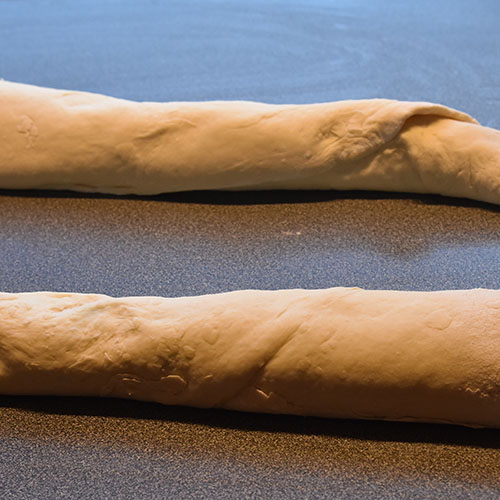 Flettet hvitløk- og basilikumbrød Ingredienser: 1 pk Gjær ½ dl Vann (fingervarmt) ½ ts Sukker 600 g Hvetemel ½ ts Salt 50 g Smør 4 dl Melk (skummet/lett) Fyll og topping: 100 g Smør (mykt) ½ bunt Basilikum (fersk) 4 fedd Hvitløk 1 Egg (sammenpisket)