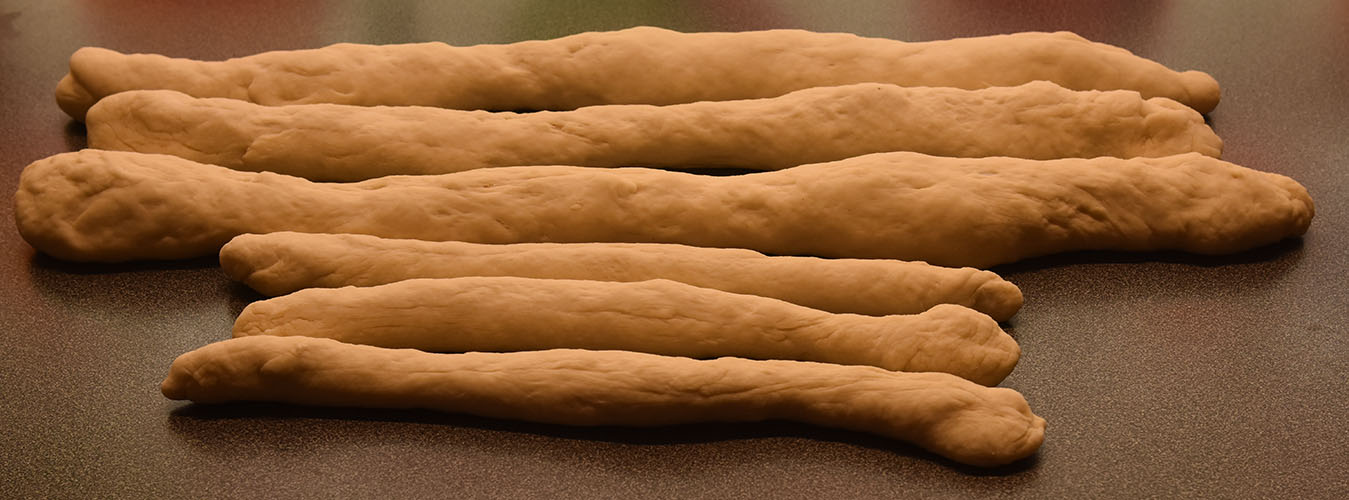 Hvetebrød i dobbel flette Ingredienser: 1 ts Salt 2 ss Olje 5 dl Vann (fingervarmt) 1 pk Gjær 2 Egg 1 ss Sukker Ca. 13 dl Hvetemel Egg (pisket), valmuefrø