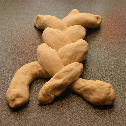 Hvetebrød i dobbel flette Ingredienser: 1 ts Salt 2 ss Olje 5 dl Vann (fingervarmt) 1 pk Gjær 2 Egg 1 ss Sukker Ca. 13 dl Hvetemel Egg (pisket), valmuefrø