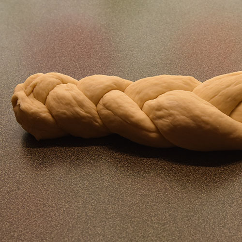 Hvetebrød i dobbel flette Ingredienser: 1 ts Salt 2 ss Olje 5 dl Vann (fingervarmt) 1 pk Gjær 2 Egg 1 ss Sukker Ca. 13 dl Hvetemel Egg (pisket), valmuefrø