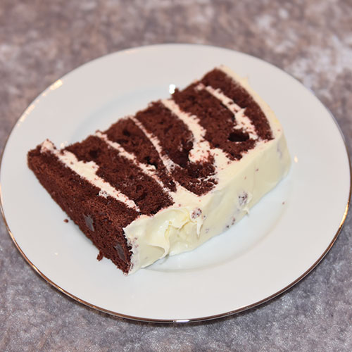 Rød sjokoladekake Ingredienser: 450 g Hvetemel (7 ½ dl) 400 g Sukker (5 dl) 4 ss Maisenna (70 g) 4-5 ss Kakao (70 g) 1 ss Natron 1 ts Bakepulver 4 Egg 3 dl Rømme 3 ½ dl Vann (varmt) 1 dl Olje (nøytral) 1 ts Vaniljeekstrakt 1 ts Eddik (eplesider) 2 ss Konditorfarge (rød) Fyll og topping: 500 g Kremost (Philadelphia) 225 g Smør 600 g Melis 1 ts Vaniljeekstrakt