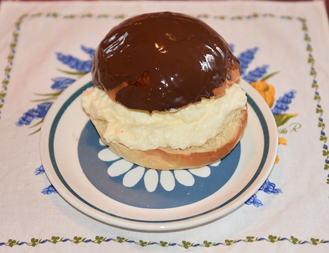 Sjokoladeboller Ingredienser 6 dl Melk 150 g Smør 1 pk Gjær 1 kg Hvetemel 1½ dl Sukker 1 Egg (sammenvispet) Kremfløte Fyll og topping (Vaniljekrem og sjokolade): 6 dl Melk 2 Egg 50 g Maizenna 1 ss Vaniljesukker 2 ss Sukker 3 dl Kremfløte 100 g Kokesjokolade