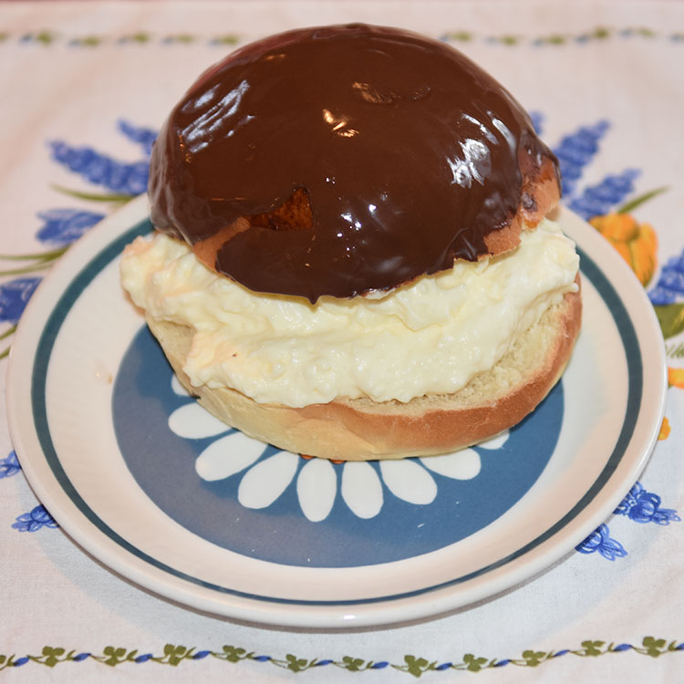 Sjokoladeboller Ingredienser 6 dl Melk 150 g Smør 1 pk Gjær 1 kg Hvetemel 1½ dl Sukker 1 Egg (sammenvispet) Kremfløte Fyll og topping (Vaniljekrem og sjokolade): 6 dl Melk 2 Egg 50 g Maizenna 1 ss Vaniljesukker 2 ss Sukker 3 dl Kremfløte 100 g Kokesjokolade