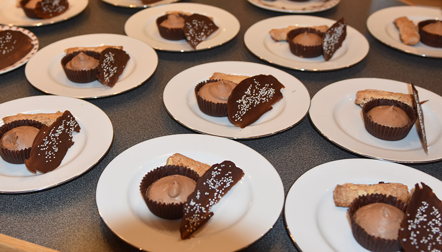 Sjokolademoussé med mandelstang, pyntet med sjokolade og sølvkuler Ingredienser: Sjokoladeskåler, og pynt: 200 g Kokesjokolade 15 Muffinsformer Kakestrø - glitter Sjokolademousse: 3 plater Gelatin 150 g Kokesjokolade 4 ss Kaffe (sterk) 3 ss Sukker 2 Egg (delte) 3 dl Kremfløte Mandelstang: 500 g Mandler (malte) 500 g melis 3-4 Eggehviter Kokesjokolade Mandelflak