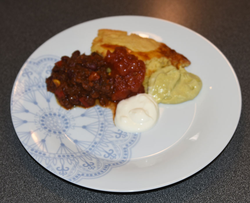 Texmex inspirert bønnegryte Ingredienser: 2 ss Olje (nøytral) 1 Løk 1 Gulrot 1 stilk Selleri 3 fedd Hvitløk 1 Stjerneanis 1 Kanelstang 1 ss Paprikapulver ½ ts Chipotlepulver 2 ts Koriander 1 ts Spisskummen 2 dl Rødvin 1 bx Tomater (hemetiske) 2 dl Vann Ca. 400 g Kidneybønner (hermetiske eller kokte) 1 ss Kakaopulver 2 Maiskolber 1 Paprika 1 ss Hakkete urter Salt og pepper