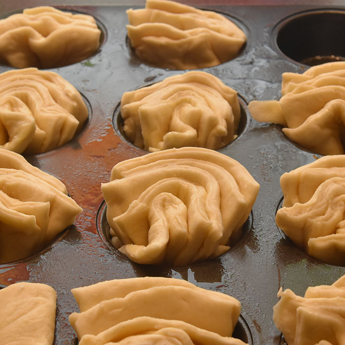 Myke Kuvertbrød stekt i muffinsformer Ingredienser: 50 g Smør 2 ½ dl Melk 25 g Gjær 1 ts Salt 2 ts Sukker 7-8 dl Hvetemel 50 g Smør til (pensling)