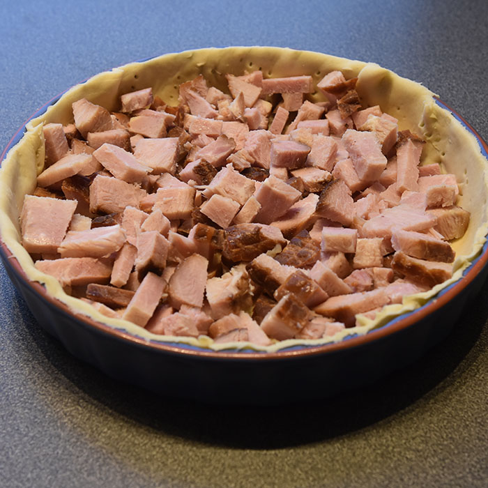 Ost- og skinkepai Ingredienser: Bunn: 3 dl Hvetemel 100 g Smør 2-4 ss Kaldt vann Fyll: 4 Egg 3 dl Melk 1 ts Salt 1 krm Pepper 150 g Skinke 100 g Ost (revet) 1 Mozzarella (i biter) 2 ss Parmesan