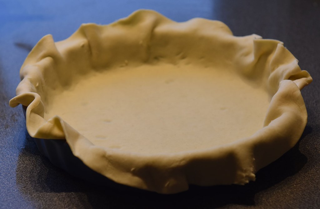 Ost- og skinkepai Ingredienser: Bunn: 3 dl Hvetemel 100 g Smør 2-4 ss Kaldt vann Fyll: 4 Egg 3 dl Melk 1 ts Salt 1 krm Pepper 150 g Skinke 100 g Ost (revet) 1 Mozzarella (i biter) 2 ss Parmesan