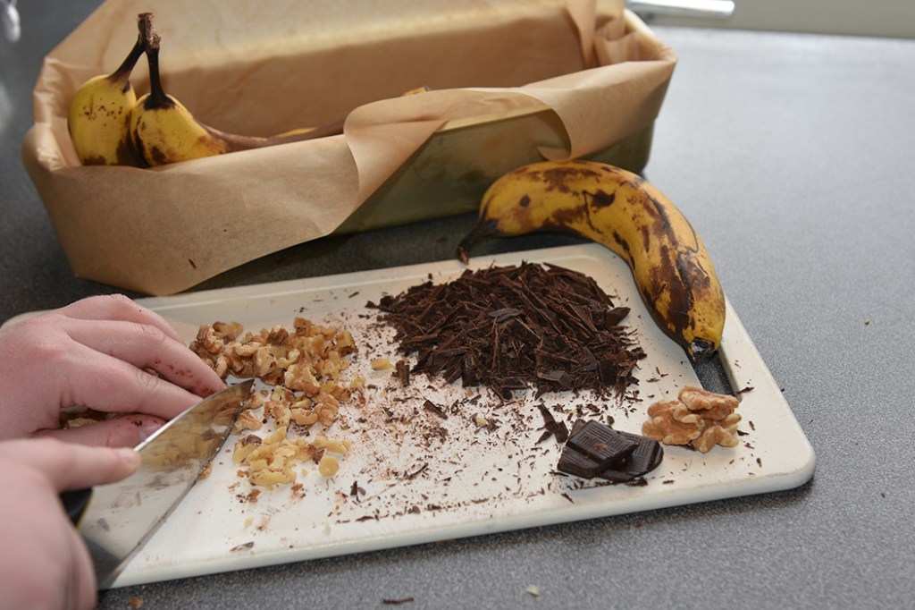 KRISTINS BANANBRØD Ingredienser: 2 ½ dl Hvetemel 2 ts Bakepulver 1 ts Vaniljesukker 1 ts Kardemomme (valgfritt) 2 Egg 1 ½ dl Sukker 50 g Smør 1 dl Melk 40 g Kokesjokolade (mørk, hakket) 40 g Valnøtter 2 Bananer (godt modne, gjerne med brune flekker) Topping: 10 g Kokesjokolade (mørk, hakket) 10 g Valnøtter 1 Banan