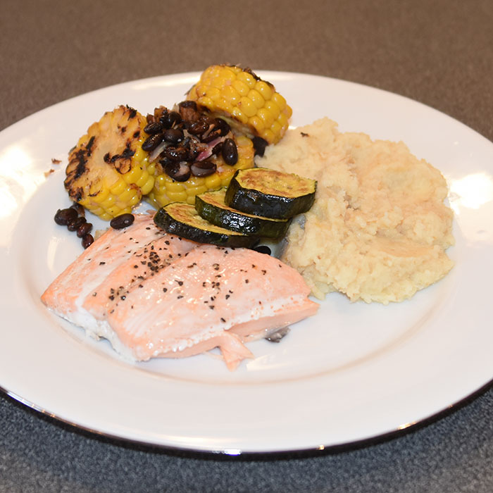 Ovnsbakt laks med sellerirotmos og svart bønnesalat 4 Laksebiter (á 100 g) 1 ss Smør Salt, pepper Sellerirotmos: 1 Sellerirot (stor) 2-3 Poteter 1 dl Melk 1 ss Smør Svart bønnesalat: Ca. 400 g Svarte bønner 2 Maiskolber (Ferdig kokte) 1 ss Olje (nøytral) 2 Sjalottløker 3 ss Sitronsaft (nypresset) 1 ss Olivenolje ½ Salt (flak)