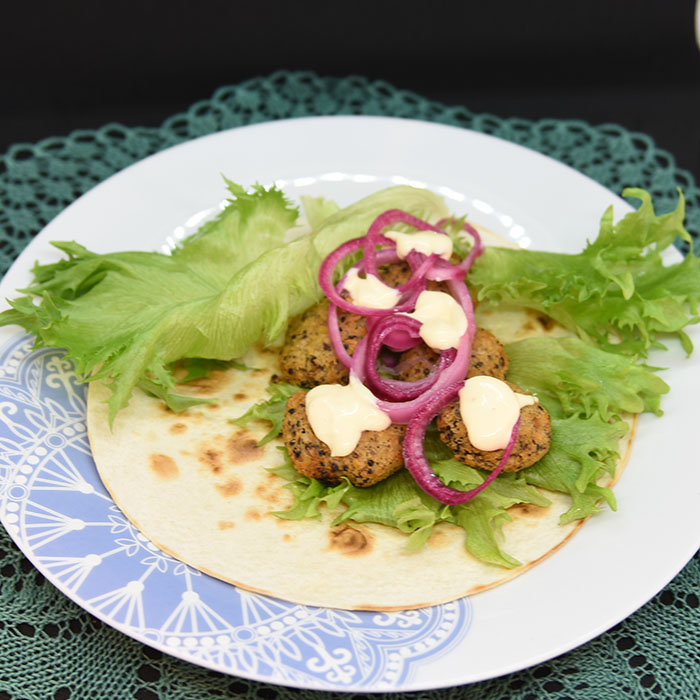 Ingredienser: 50 g Quinoa 1 dl Grønsakskraft (eller -buljong) 400 g Bønner (hvite) 1 Sjalottløk ½ ts Kajennepepper 1 ts Paprikapulver 1 ss Oregano (tørket) 1 ts Koriander (malt) 1 ss Ketchup 30 g Brødrasp 1 Egg Salt, pepper Olje 6 Tortillalefser Salat Syltet rødløk: 1 Rødløk 1 dl Vann ½ dl Eddik (7%) 1 dl Sukker Chilimajones: 2 dl Majones 1 ss Rømme 2 ts Sursøt-chilisaus 1 ts Sitronsaft Salt og pepper