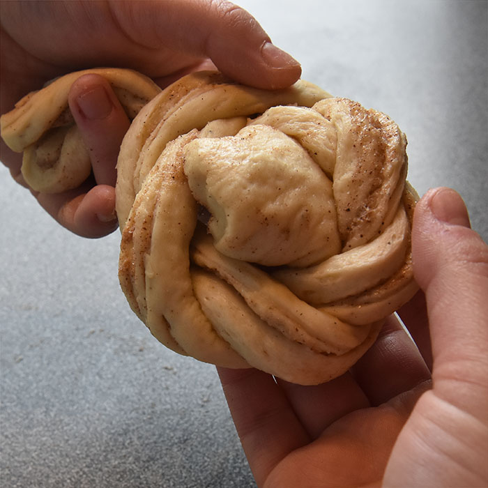 Fies Kanelsnurrer Ingredienser: 1 pk Gjær 5 dl Melk 1 Egg 1 kg Hvetemel 150 g Sukker 2 ts Kardemomme 1 ts Salt 150 g Smør (romtemperert) Fyll og pynt: 100 g Smør Sukker og kanel Egg til pensling Perlesukker