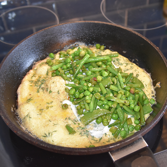 Grønn omelett Ingredienser: 200 -250 g Erter, sukkererter, aspargesbønner og asparges (skjært i mindre biter) 4 Egg Salt, pepper 4 ts Vann Dill og persille 4 ss Smør 2-3 ss Rømme (lett)