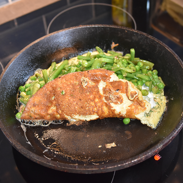 Grønn omelett Ingredienser: 200 -250 g Erter, sukkererter, aspargesbønner og asparges (skjært i mindre biter) 4 Egg Salt, pepper 4 ts Vann Dill og persille 4 ss Smør 2-3 ss Rømme (lett)