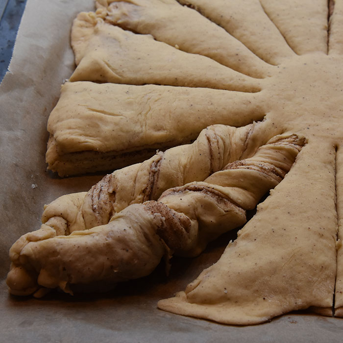 Maiblomst Ingredienser: ¾ pk Gjær 3 dl Melk (fingervarm) 2 Egg 675 g Hvetemel 75 g Sukker ½ ts Salt 3 ts Kardemomme 2 ts Kanel 100 g Smør (romtemperert) Fyll & Topping: Smør, sukker, kanel Perlesukker