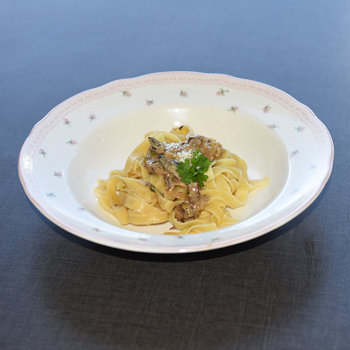 Tagliatelle med kylling- og sjampinjongsaus Ingredienser: 400 – 500 g Tagliatelle (eller annen pasta) 2 Kyllingbryst 1 ss Olivenolje 1 ss Smør 2 skiver Bacon (hakket) 350 g Sjampinjonger (skivet) 1 Buljongterning (grønnsak/kylling) 1 dl Melk 2 dl Kremfløte ¼ Purreløk (skivet) 50 g Parmesan 1 ss Persille (hakket) Salt, pepper