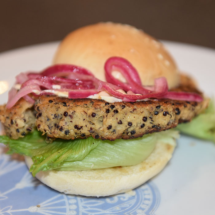 Quinoaburger Ingredienser: 50 g Quinoa 1 dl Grønsakskraft (eller -buljong) 400 g Bønner (hvite) 1 Sjalottløk ½ ts Kajennepepper 1 ts Paprikapulver 1 ss Oregano (tørket) 1 ts Koriander (malt) 1 ss Ketchup 30 g Brødrasp 1 Egg Salt, pepper Olje 4 Hamburgerbrød Salat
